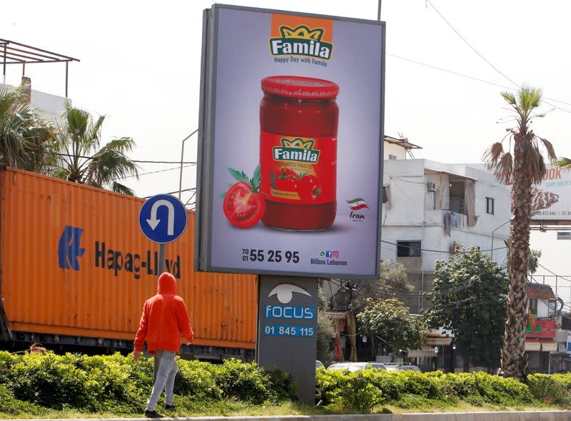 Man walks past an advertising billboard in Beirut suburbs