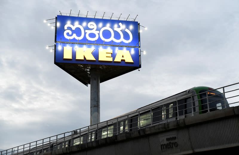 A metro train moves past a signboard of new IKEA store in Bengaluru