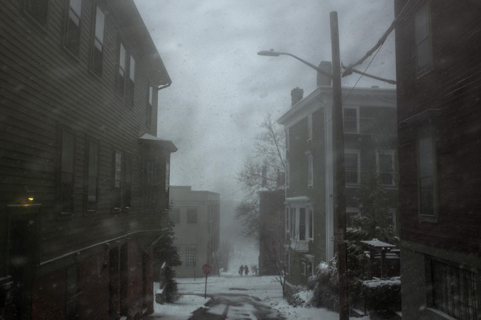 Pedestrians make their way through falling snow and wind gusts, Sunday, Jan. 7, 2024, in Providence, R.I. A major winter storm bringing heavy snow and freezing rain to some communities spread across New England on Sunday morning, sending residents scurrying to pull out their shovels and snowblowers to clear sidewalks and driveways. (AP Photo/David Goldman)