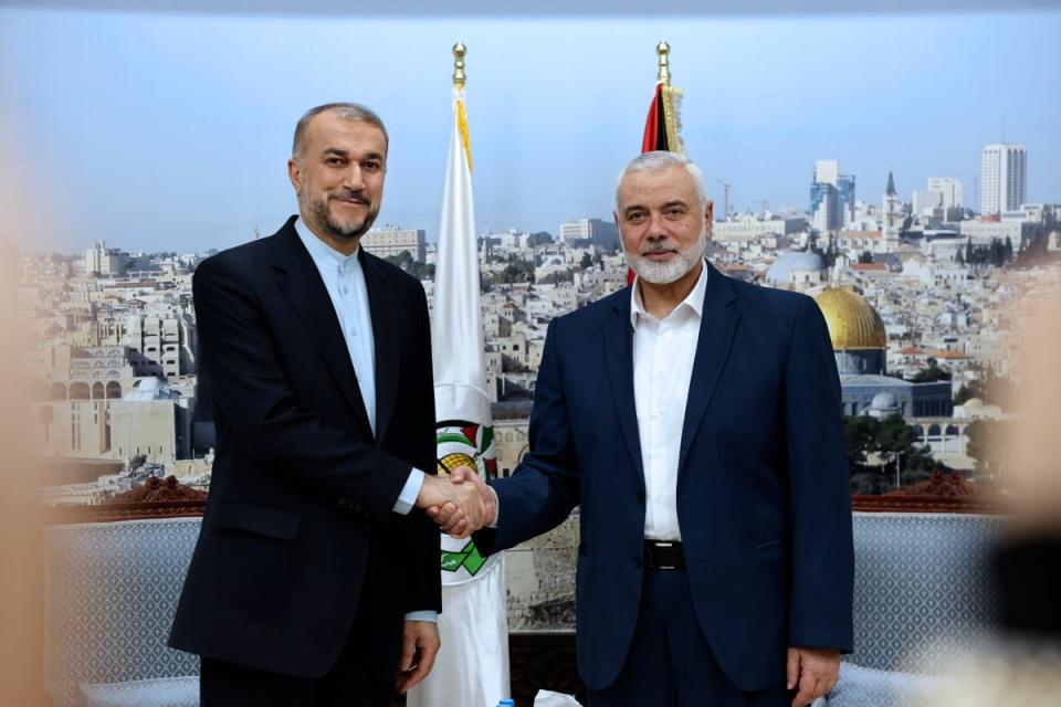 Iran’s foreign minister Hossein Amir-Abdollahian (left) shakes hands with Hamas chief Ismail Haniyeh, during a meeting in Doha, Qatar (AP)