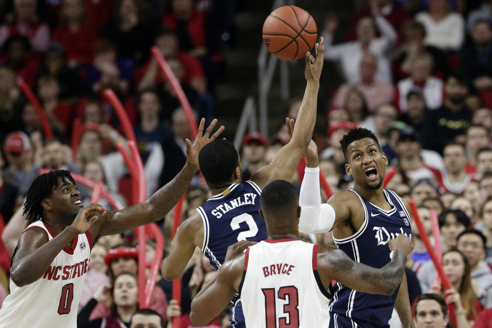 CORRECTS NC STATE PLAYER NO. 13 TO C.J. BRYCE, INSTEAD OF JOEY BAKER - Duke guard Cassius Stanley (2) and forward Javin DeLaurier, right, chase the ball with North Carolina State forward D.J. Funderburk (0) and guard C.J. Bryce during the first half of an NCAA college basketball game in Raleigh, N.C., Wednesday, Feb. 19, 2020. (AP Photo/Gerry Broome)