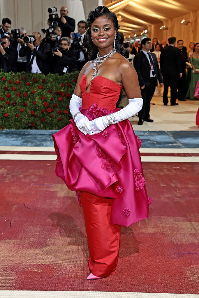 Denee Benton smiles and stands on the red carpet