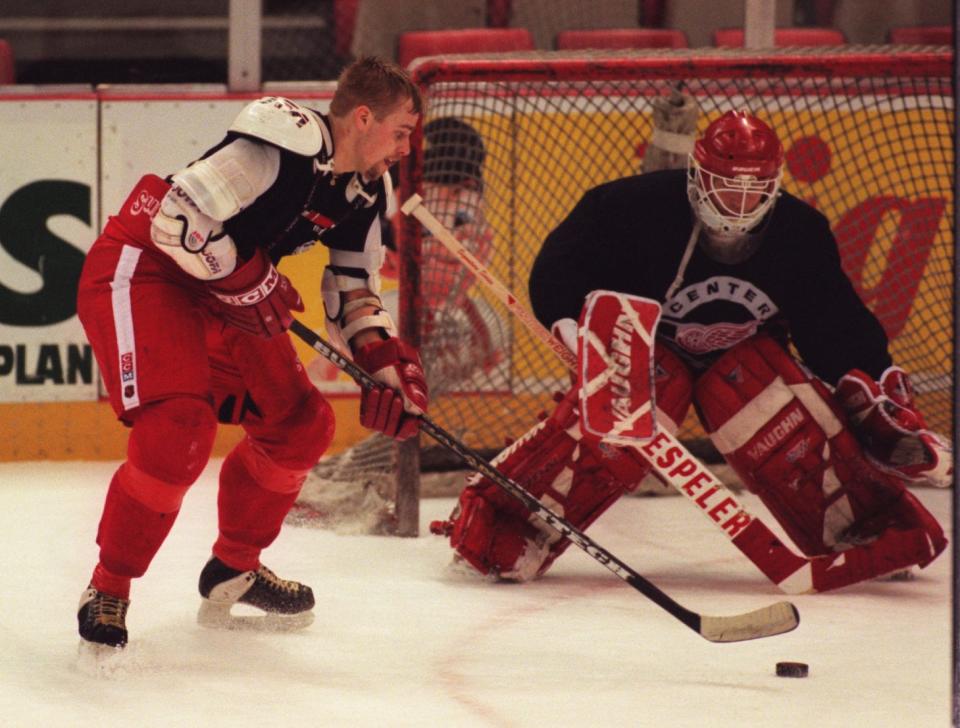 Playing "Shirts and Skins" at the end of Detroit Red Wings practice, Tomas Holmstrom has the puck as goalie Chris Osgood watches in front of the net at Joe Louis Arena, May 1, 1997.