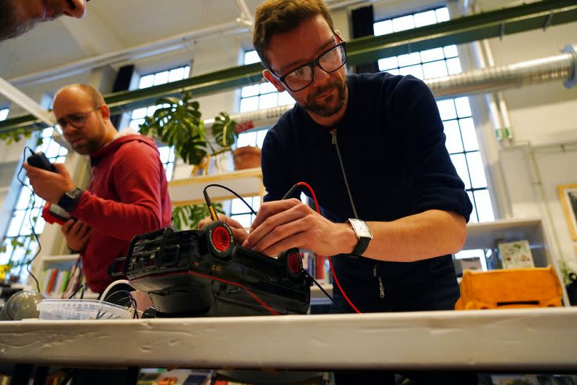Ein Freiwilliger repariert einen ferngesteuerten Spielzeuglastwagen bei einer Repair-Café-Veranstaltung in Malmö, November 2021