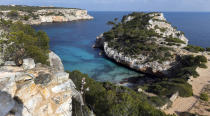 FILE - In this Friday, March 21, 2014 file photo, the Cap des Moro near Cala Llombards on the Spanish Balearic island of Mallorca. Spain’s Balearic Islands will allow thousands of German tourists to fly in from beginning June 15, 2020, for a two-week trial testing out how new tourism rules work in the coronavirus era. (AP Photo/Matthias Schrader, File)