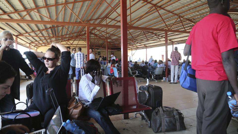 Locals and foreign nationals gather at Juba International Airport as they wait for flights out of the South Sudanese capital Juba