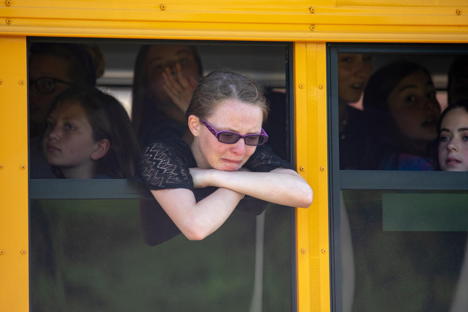 Evacuated middle school students wait on a bus outside Noblesville High School.&nbsp;