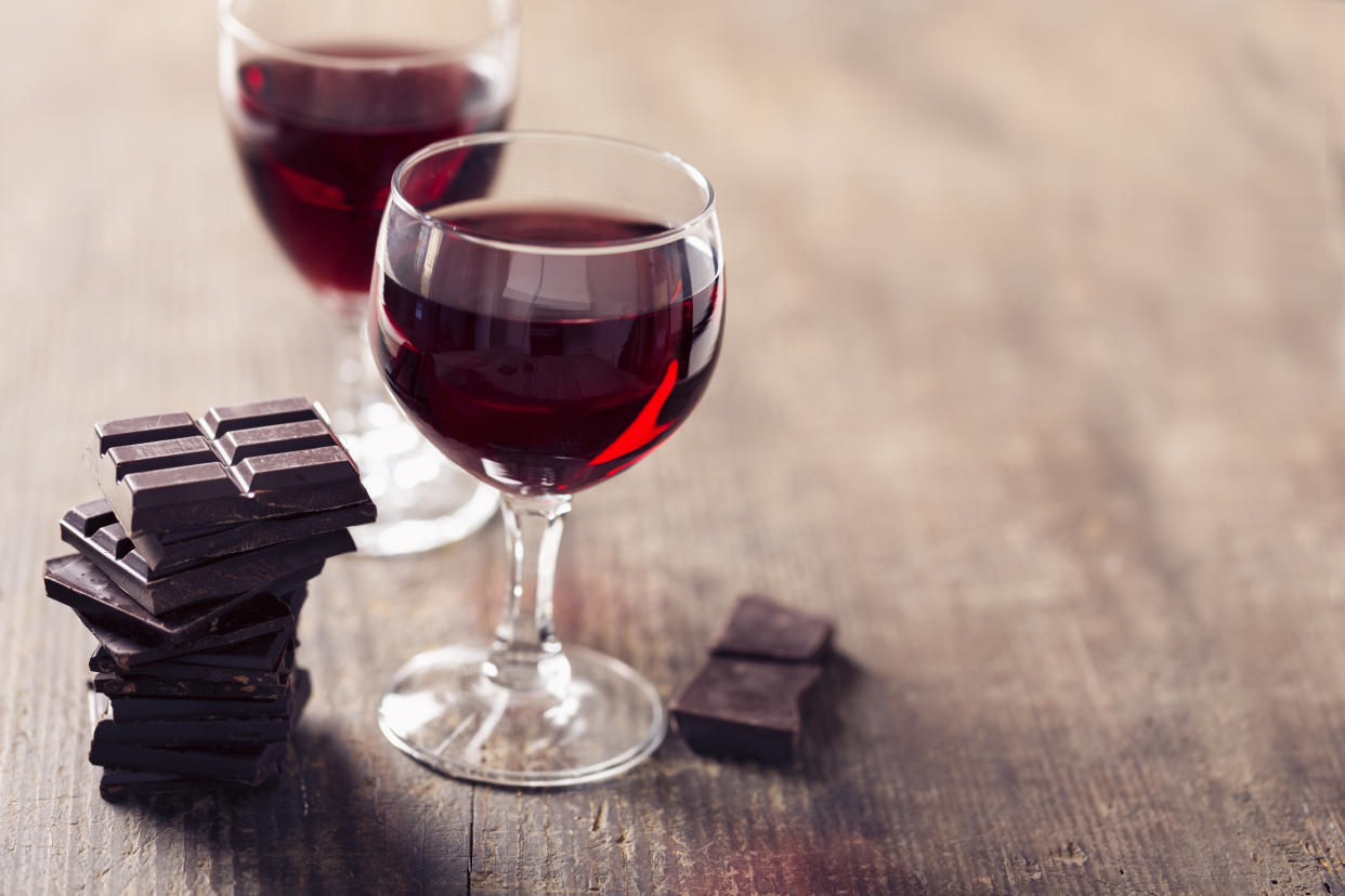 2 glaases with red wine and dark chocolate on wooden background, a wonderful combination