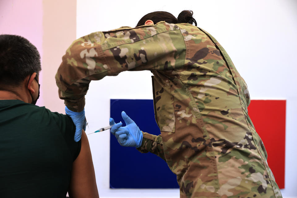 A member of the Maryland National Guard administers a coronavirus vaccine