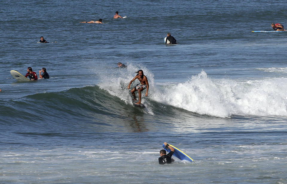 FILE - A surfer rides a wave in the Atlantic Ocean in Biarritz, southwestern France, Oct. 7, 2023. October was the fifth straight month that Earth set a record for the hottest month in recorded history. (AP Photo/Bob Edme, File)