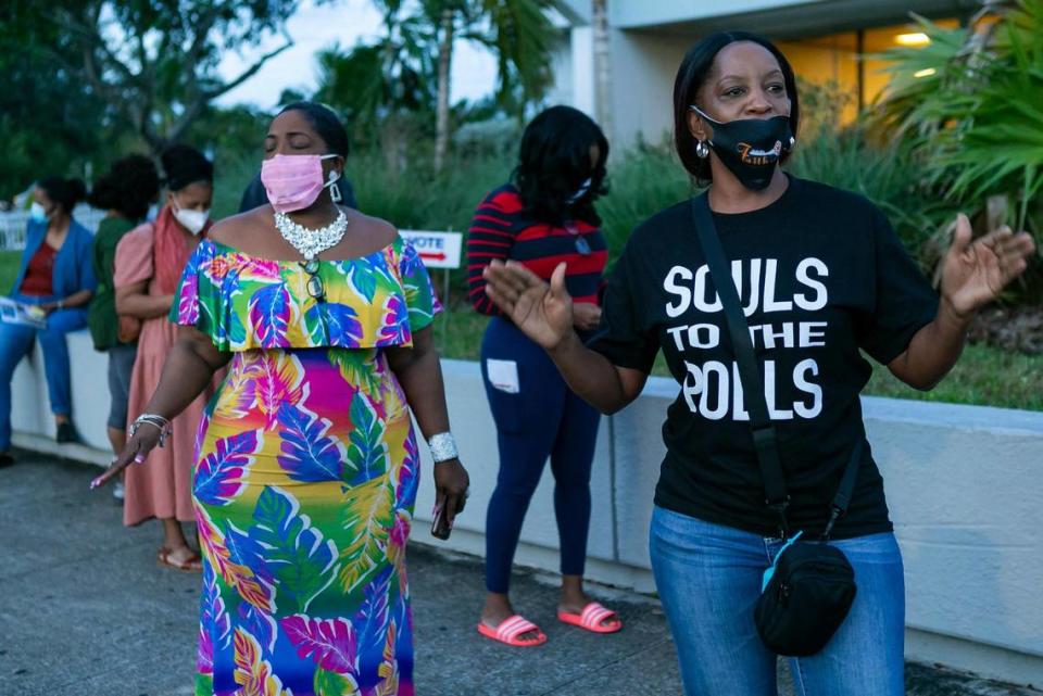 Pastor Stephanie E. Russell, right, and Denise Mills Mincey, left, pray as voters lineup to cast their early ballots at the North Dade Regional Library in Miami Gardens on Saturday, October 24, 2020. Faith in Florida, a federation of the national faith-based grassroots organization Faith in Action, hosted Prayer at the Polls events like this one across the state Saturday.