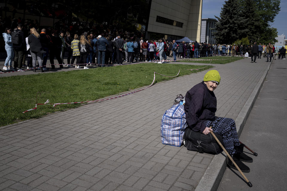 Didenko Ekaterina, 93, from the Ukrainian city of Vuhledar, waits for her daughter as people stay in line for registration at the aid distribution center for displaced people in Zaporizhia, Ukraine, Thursday, May 5, 2022. (AP Photo/Evgeniy Maloletka)