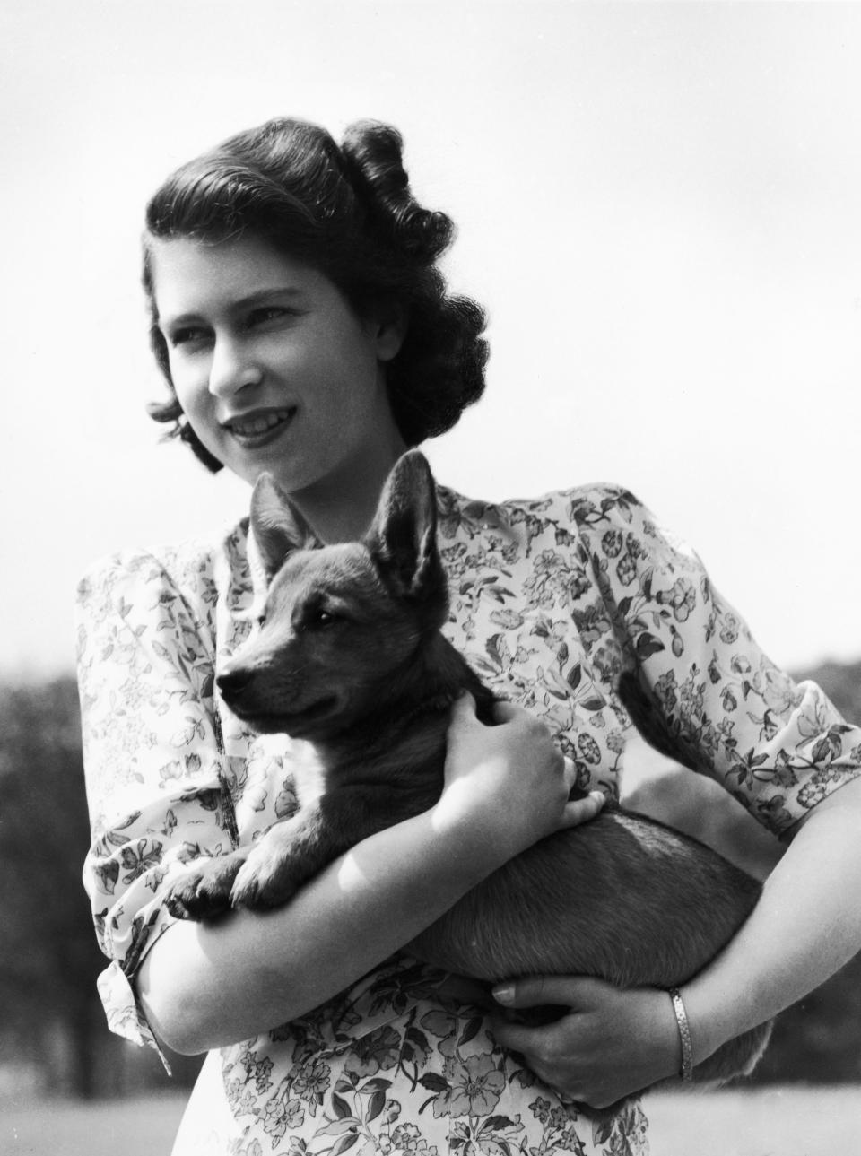 1944: Princess Elizabeth holding Sue, a corgi pup, in the grounds of Windsor Castle, Berkshire, on May 30, 1944.