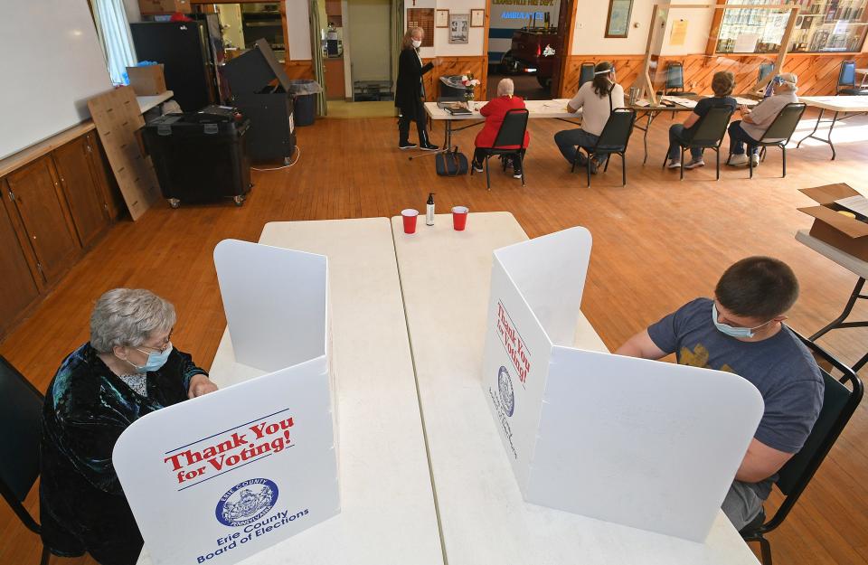 Ann VanSlyke, 84, at left, and Michael Rizzo, 37, at right, fill out their ballots, May 18, 2021, at the Cranesville Fire Department’s social hall during the primary election. Election officials at the Cranesville Borough voting precinct hoped for about 30% turnout for the primary.