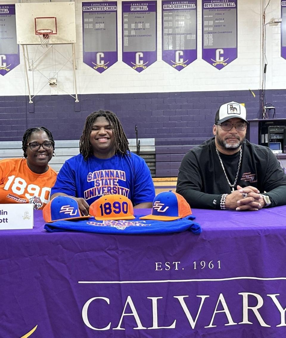 Jalin Scott of Calvary Day, with his parents, as he signed to play football at Savannah State Wednesday.