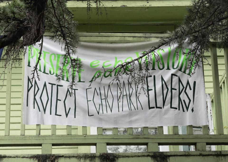 A sign that says "Protect Echo Park Elders" hangs on a fence.