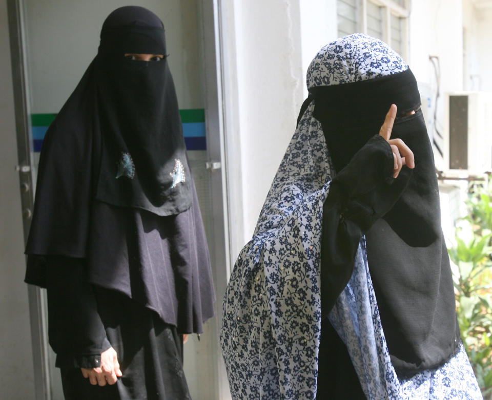 Filipino sisters and independent filmmakers Nadioua Bansil, left, and Linda Bansil, emerge from a news conference following a news conference at the Western Mindanao Command in Zamboanga, southern Philippines Friday, Feb.21, 2014. The sisters were kidnapped by Muslim extremists eight months ago and escaped from their captors Thursday evening in the jungles of the southern Philippines and told authorities they were kept in isolation in a hut on a meager diet. (AP Photo)