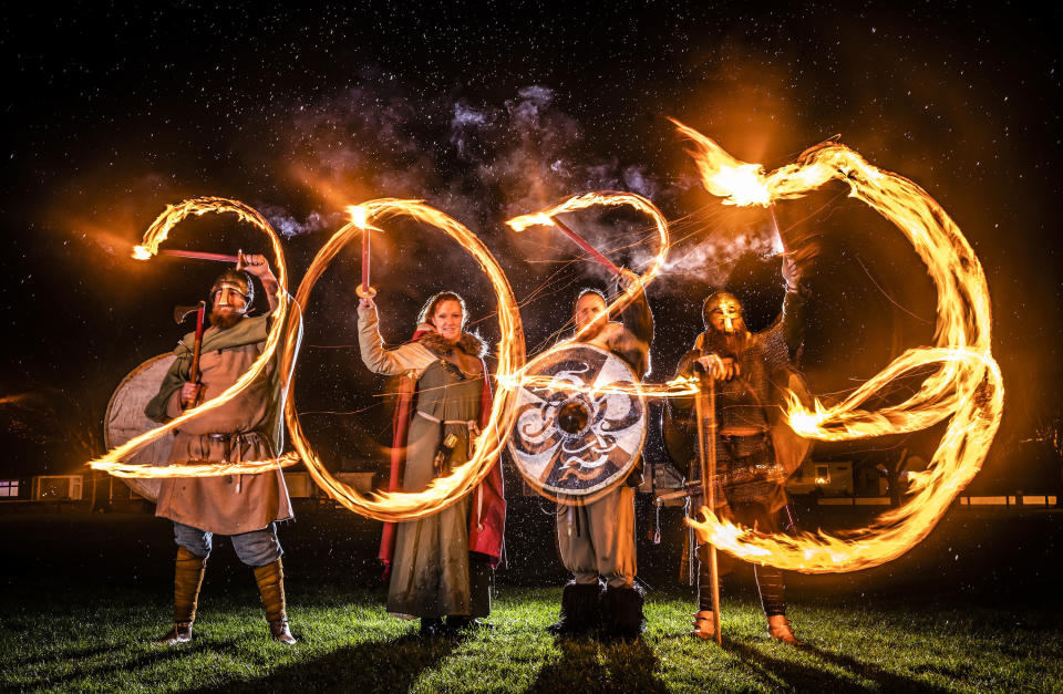 Viking reenactors use flaming torches to write 2023 at the Flamborough Fire Festival, a Viking themed parade in aid of charities and local community groups, held on New Year's Eve in Flamborough near Bridlington, England, Saturday Dec. 31, 2022. (Danny Lawson/PA via AP)