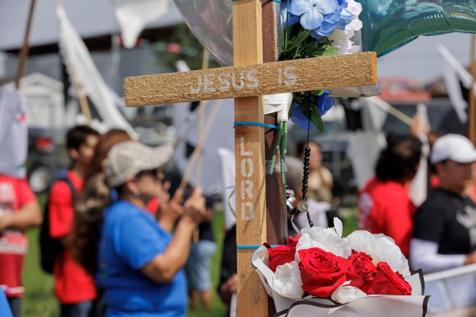 A cross stands at a memorial for eight migrants who were run over and killed waiting at a bus stop on May 8, 2023, in Brownsville, Texas.