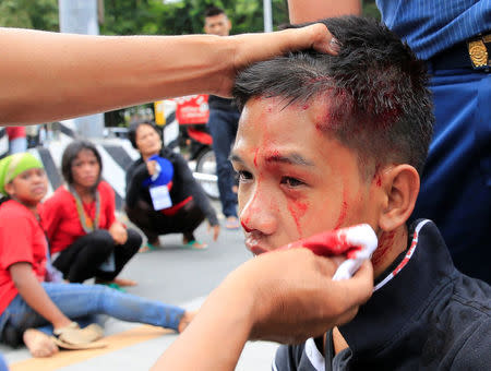 A medic applies first aid to a wounded demonstrator after a violent dispersal of various activist and Indigenous People's (IP) groups protesting against the continuing presence of U.S. troops in the Philippines in front of the U.S. Embassy in metro Manila, Philippines October 19, 2016. REUTERS/Romeo Ranoco