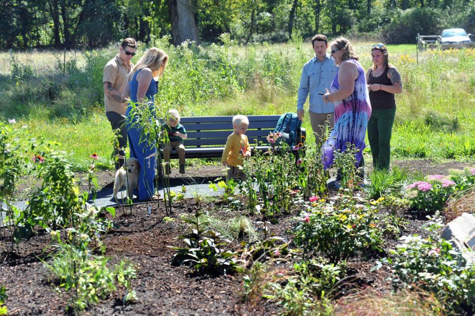 Family members and friends admire the memorial garden honoring the legacy of the town's late conservation agent, Nancy Hemingway, who died in 2020 of breast cancer at age 59.