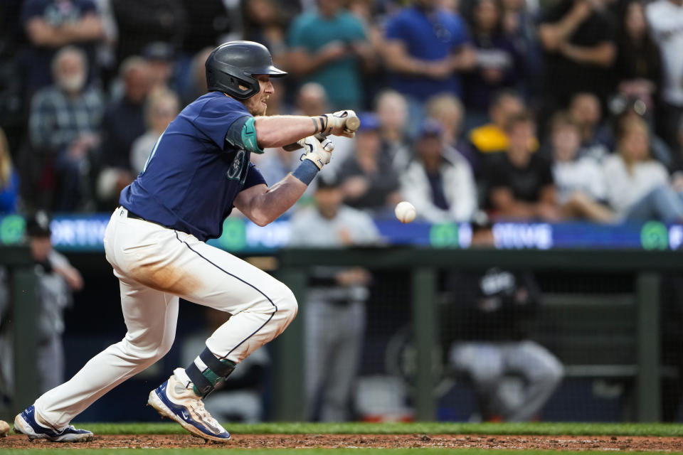 Seattle Mariners' Luke Raley bunts for an RBI single to score Josh Rojas against the Chicago White Sox during the eighth inning of a baseball game Monday, June 10, 2024, in Seattle. (AP Photo/Lindsey Wasson)