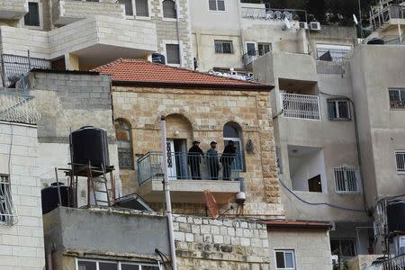 Israeli guards stand on the balcony of a house purchased by Jews in the mostly Arab neighbourhood of Silwan in east Jerusalem October 20, 2014. REUTERS/Ronen Zvulun