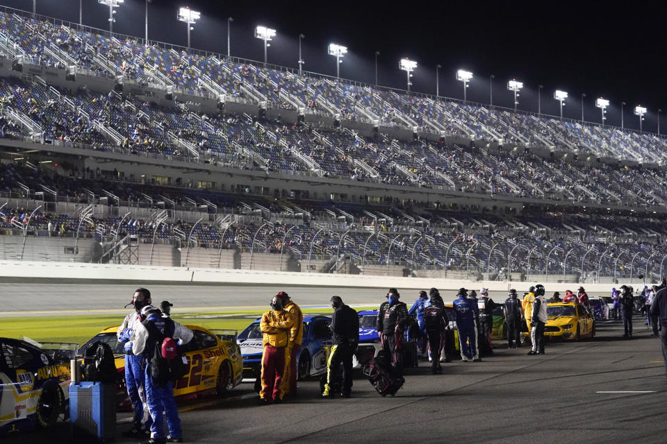 Drivers return to their cars after a weather delay during the NASCAR Daytona 500 auto race at Daytona International Speedway, Sunday, Feb. 14, 2021, in Daytona Beach, Fla. (AP Photo/John Raoux)