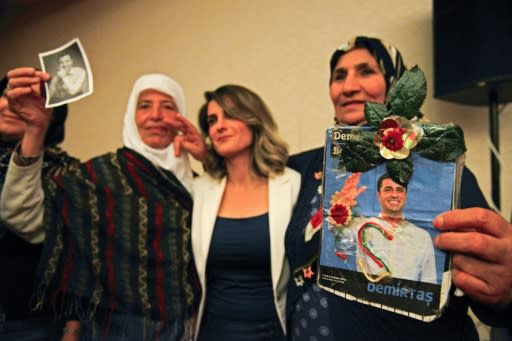 Basak Demirtas (C), wife of Selahattin Demirtas, who has been in jail for a year and a half, is flanked by women holding pictures of the Kurdish leader who is challenging Turkish President Recep Tayyip Erdogan at the polls