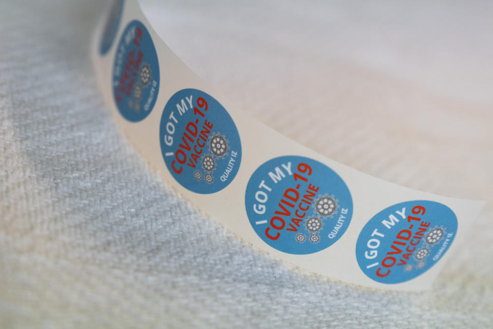 In this Wednesday, Feb. 10, 2021, photo stickers are at the ready as healthcare workers and people over the age of 65 receive COVID-19 vaccinations at United Medical Center in southeast Washington. (AP Photo/Jacquelyn Martin)