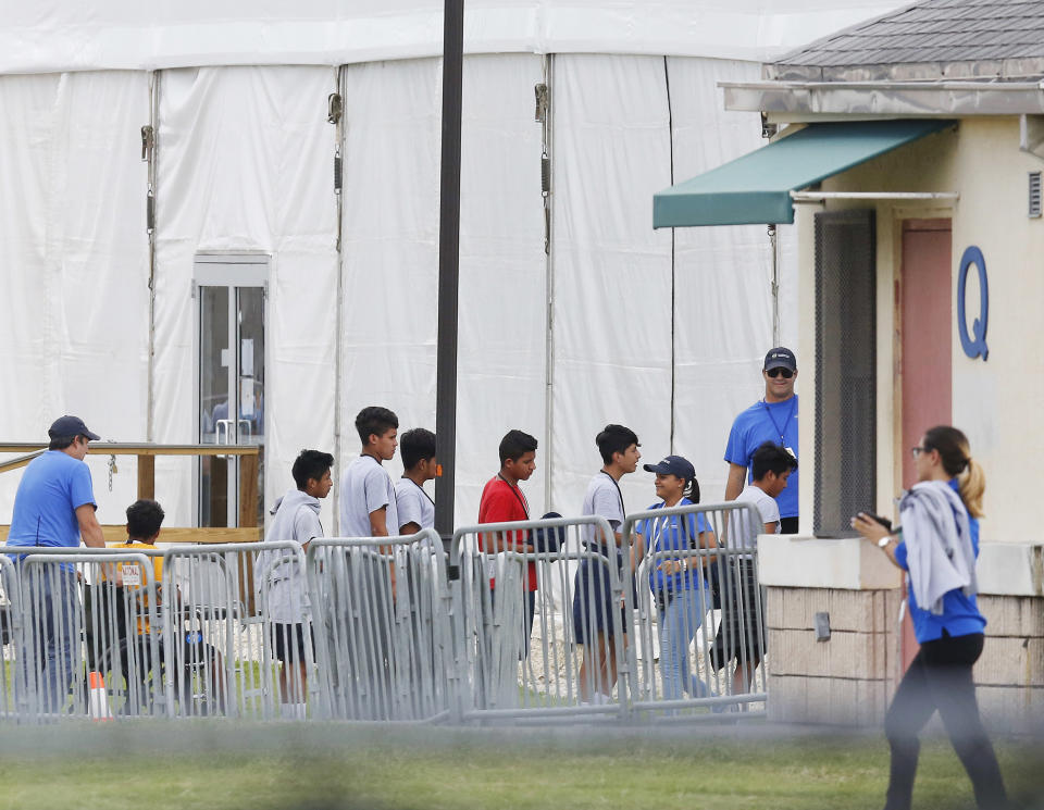 FILE - In this June 20, 2018 photo, immigrant children walk in a line outside the Homestead Temporary Shelter for Unaccompanied Children a former Job Corps site that now houses them in Homestead, Fla. Migrant children who were separated from their parents at the U.S.-Mexico border last year suffered post-traumatic stress and other serious mental health problems, according to a government watchdog report obtained by The Associated Press Wednesday. The chaotic reunification process only added to their trauma. (AP Photo/Brynn Anderson, File)