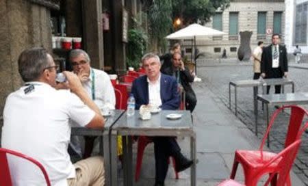 President of the International Olympic Committee (IOC), Thomas Bach (C), sits at a sidewalk cafe next to Rio 2016 organizing committee Communications Director Mario Andrada, in downtown Rio de Janeiro, Brazil, July 27, 2016. REUTERS/Rodrigo Viga