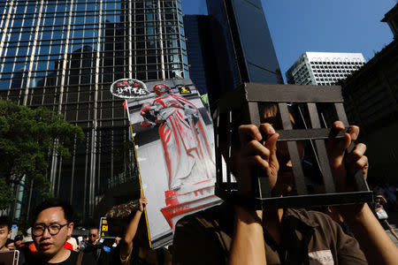 A demonstrator covers his head with cardboard jail bars, as he protests of the jailing of student leaders Joshua Wong, Nathan Law and Alex Chow, who were imprisoned for their participation of the 2014 pro-democracy Umbrella Movement, also known as "Occupy Central" protests, in Hong Kong China August 20, 2017. REUTERS/Tyrone Siu