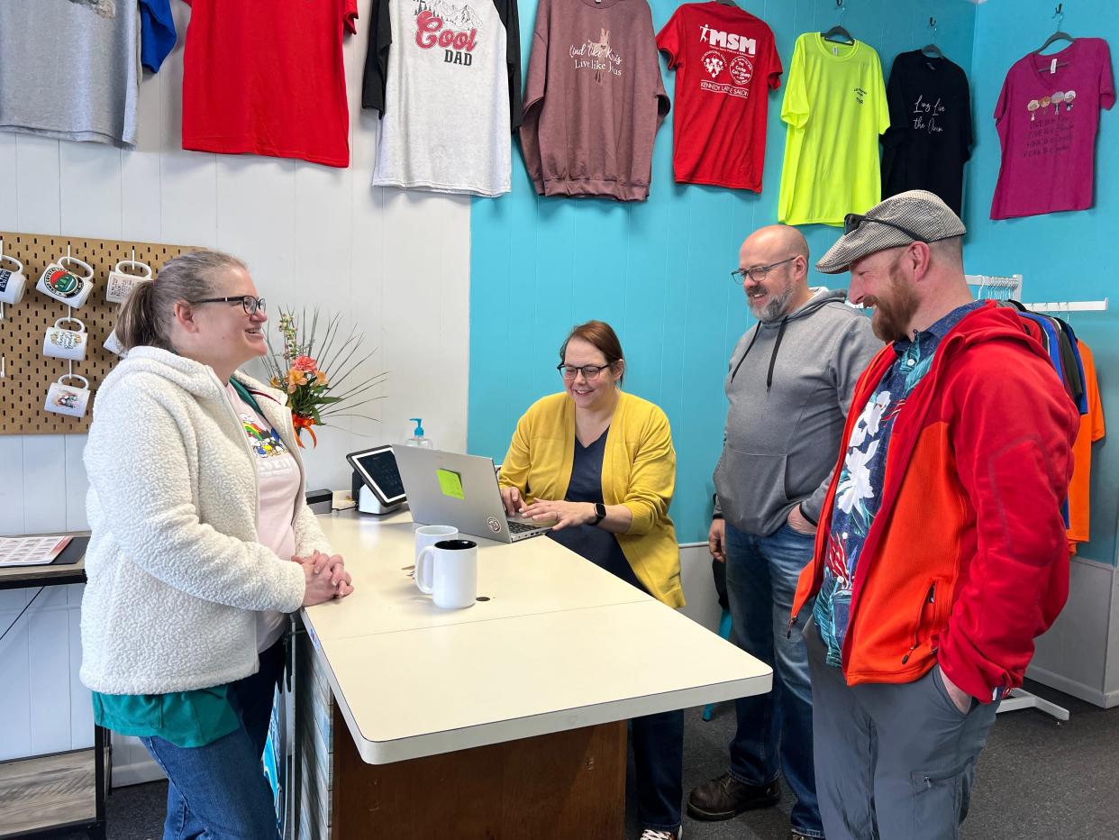 Rachel and Kevin Myers wait on customers Jeremy and Laura West as they purchase shirts from the Print Happier in downtown Bucyrus. Rachel Myers opened the shop just before the pandemic hit in 2020. (KIMBERLY GASURAS FOR TELEGRAPH-FORUM)