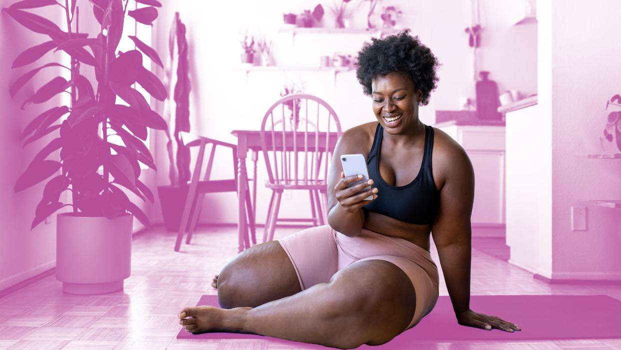 HUED app helps patients of color find healthcare providers of color in their area. , Plus size african woman relaxing after exercising at home. Female in sportswear using mobile phone after doing workout at home.