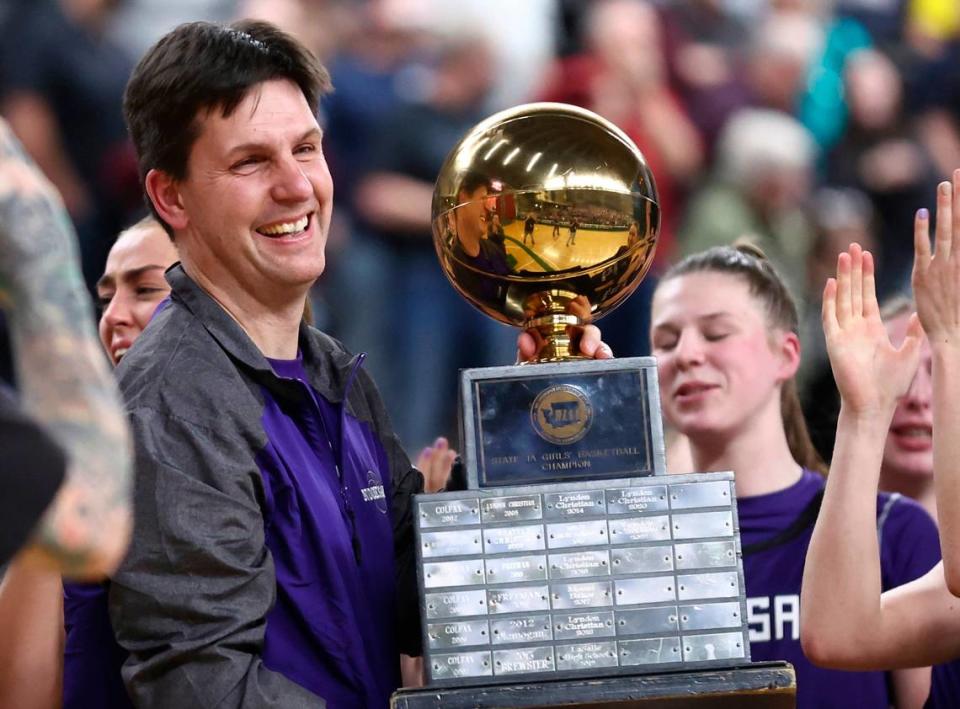 Nooksack Valley coach Shane Wichers lifts the Class 1A state trophy on Saturday, March 4, 2023 at the Yakima Valley SunDome in Yakima, Wash.