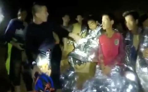 Boys from the under-16 soccer team trapped inside Tham Luang cave greet members of the Thai rescue team - Credit: REUTERS