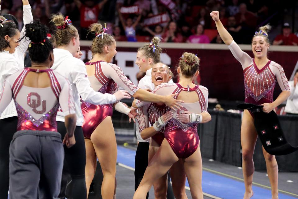 Olivia Trautman, center, celebrates with her OU teammates after scoring a perfect 10 on the vault during a women's college gymnastics meet against Florida on Friday at Lloyd Noble Center in Norman.