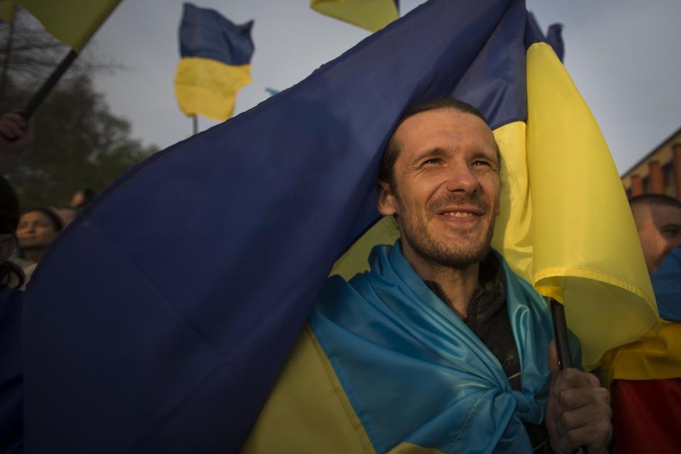 A man holds a Ukrainian national flag during a rally in support of a united Ukraine in Donetsk, Ukraine, Thursday, April 17, 2014. Defense Secretary Chuck Hagel says the U.S. will send nonlethal assistance to Ukraine's military in light of what he called Russia's ongoing destabilizing actions there. (AP Photo/Alexander Zemlianichenko)