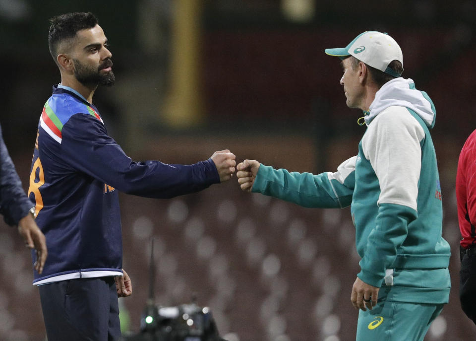 India's Virat Kohli, left, gestures with Australian coach Justin Langer following the one day international cricket match between India and Australia at the Sydney Cricket Ground in Sydney, Australia, Sunday, Nov. 29, 2020. (AP Photo/Rick Rycroft)