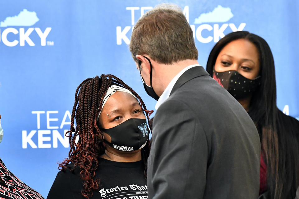 Kentucky Gov. Andy Beshear talks with Tamika Palmer, the mother of Breonna Taylor, following the signing of a partial ban on no-knock warrants, Friday, April 9, 2021, at the Center for African American Heritage in Louisville, Ky. The bill signing comes after months of demonstrations set off by the fatal shooting of Taylor in her home during a botched police raid. (AP Photo/Timothy D. Easley)