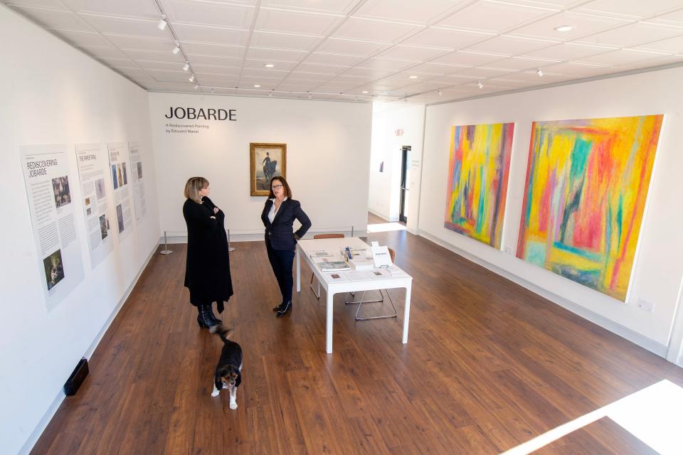 Caitlin Kelly-McKenna, left, owner and founder, and Megan Hay Guglielmo, gallery senior adviser, stand in at Kelly-McKenna Gallery in Spring Lake as Kelly-McKenna's dog Moses wanders the exhibition space. Monday, February 13, 2023.
