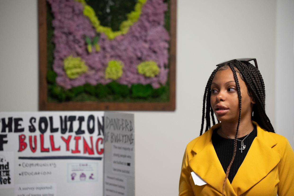 Myanna Brown, 14, presents a project on solutions to bullying with Makailah Richards, 15, and Bella Gregory, 16 (not pictured) at Femergy. All three girls presenting had personal experience with bullying.