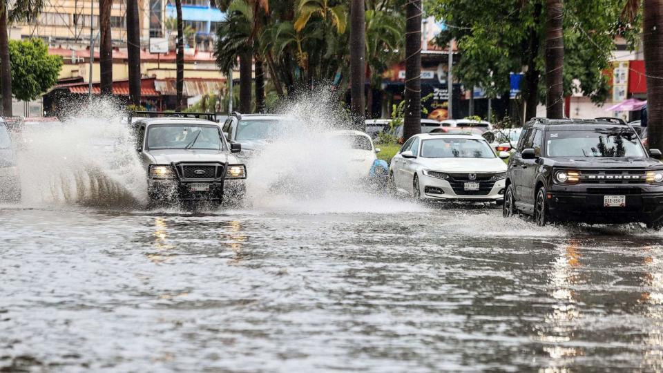 PHOTO: Cars move on a flooded street due to heavy rains in the resort of Acapulco, Guerrero state, Mexico, on Aug. 16, 2023. (David Guzman/EPA via Shutterstock)