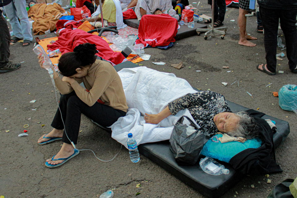 Earthquake survivors are treated outside of a hospital in Cianjur, West Java, Indonesia, Monday, Nov. 21, 2022. An earthquake shook Indonesia's main island of Java on Monday damaging dozens of buildings and sending residents into the capital's streets for safety. (AP Photo/Kholid)