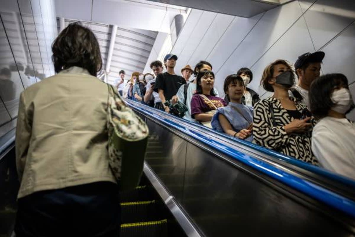 File photo: People ride on an escalator at Shinjuku station in Japan on 1 June 2023 (AFP via Getty Images)
