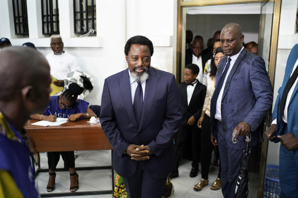 Congolese President Joseph Kabila, center, arrives to cast his vote Sunday, Dec. 30, 2018 in Kinshasa, Congo. Forty million voters are registered for a presidential race plagued by years of delay and persistent rumors of lack of preparation. (AP Photo/Jerome Delay)