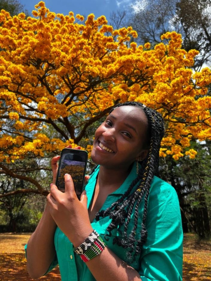 Elizabeth Wathuti, Kenyan environment and climate activist displays a photograph she took after a Reuters interview at the Nairobi Arboretum, botanical garden, in Nairobi, Kenya October 8, 2022.