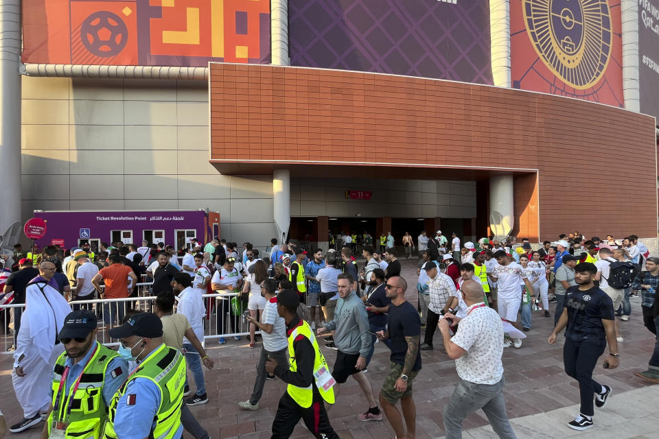 Fans arrive for the World Cup group B soccer match between England and Iran at the Khalifa International Stadium Doha, Qatar, Monday, Nov. 21, 2022. Problems with FIFA's mobile application for World Cup match tickets have delayed fans from getting into the stadium to watch England play Iran in the second game of the tournament. Hundreds of fans were lined up outside the Khalifa International Stadium less than an hour before the 4 p.m. kickoff in Doha. (AP Photo/Steve Wade)