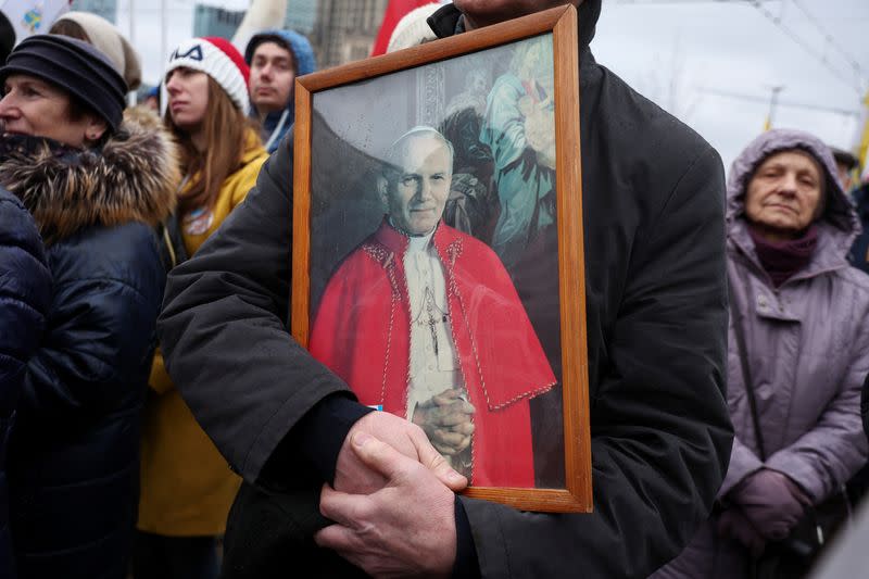 People march in defense of pope John Paul II on his death anniversary in Warsaw